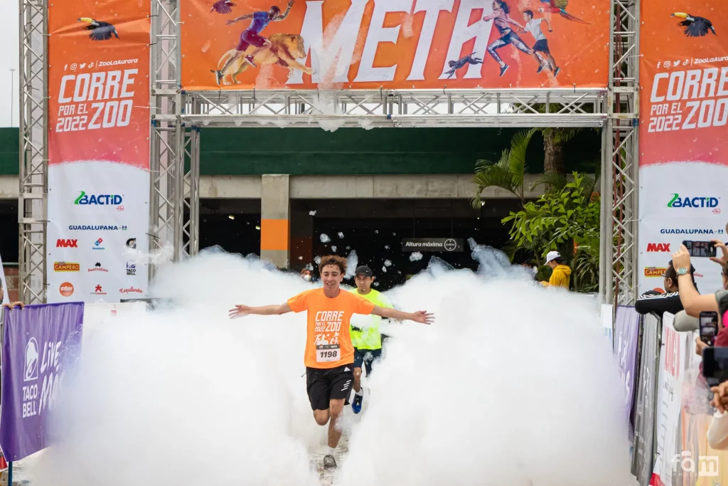 An image of the "Corre por el Zoo" 5k race, with runners appearing through a mass of bubbles.