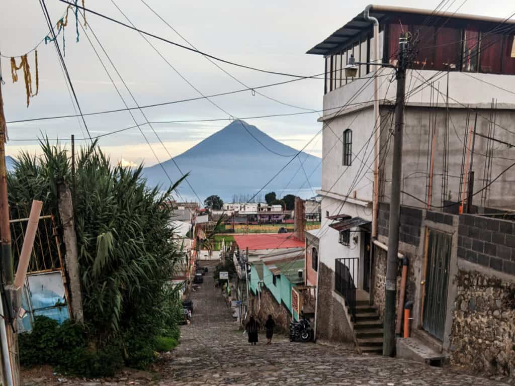 Calle empedrada en Sololá con un volcán elevándose al fondo. Es el tipo de escena que puedes ver en un viaje en lanzadera de Antigua a Panajachel.