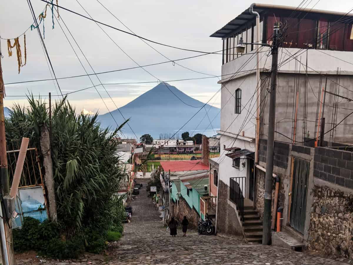 Calle empedrada en Sololá con un volcán elevándose al fondo. Es el tipo de escena que puedes ver en un viaje en lanzadera de Antigua a Panajachel.